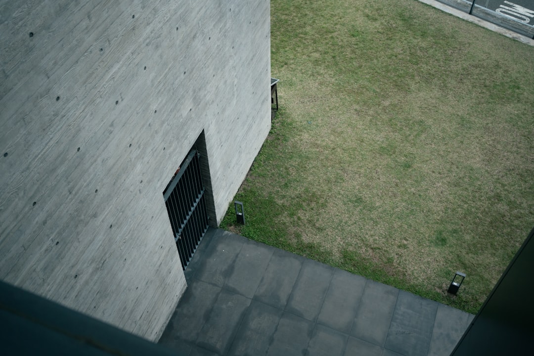 Concrete building exterior with grassy courtyard and pathway.