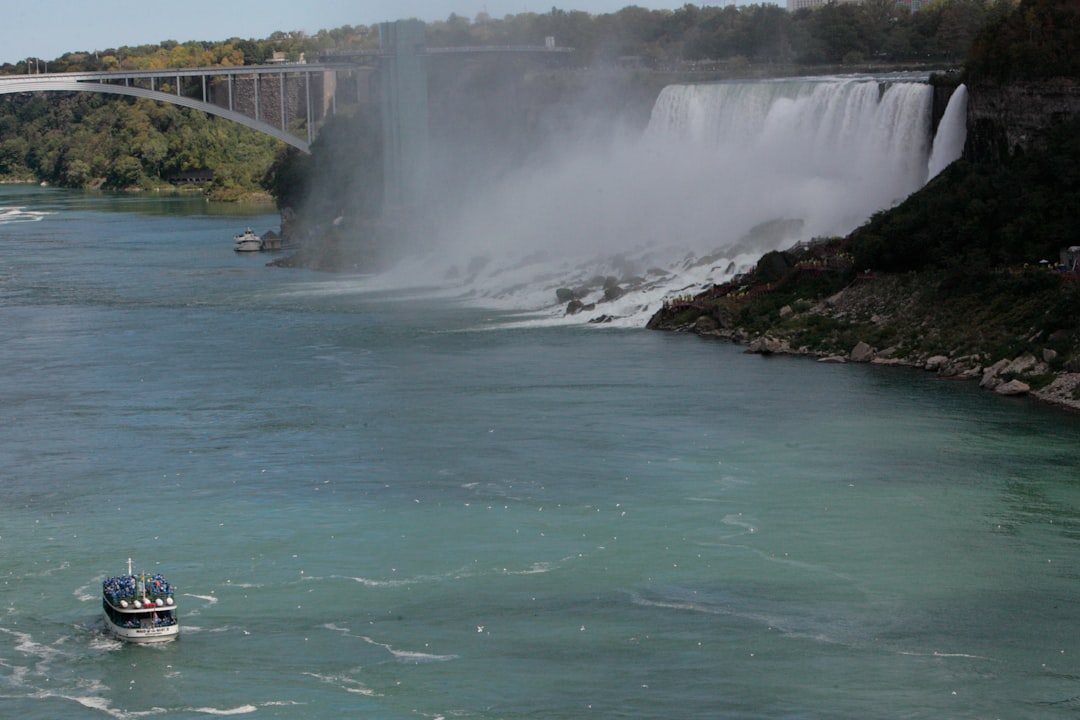 a boat in the water by a waterfall