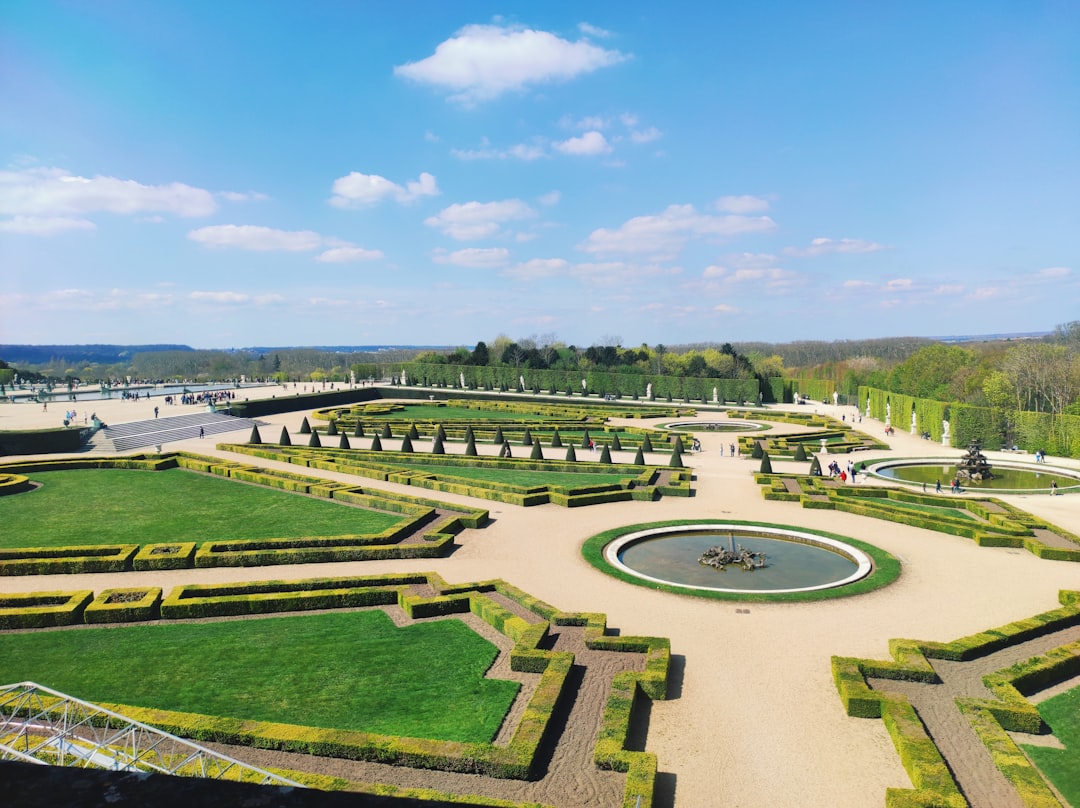 a large garden with a fountain surrounded by hedges